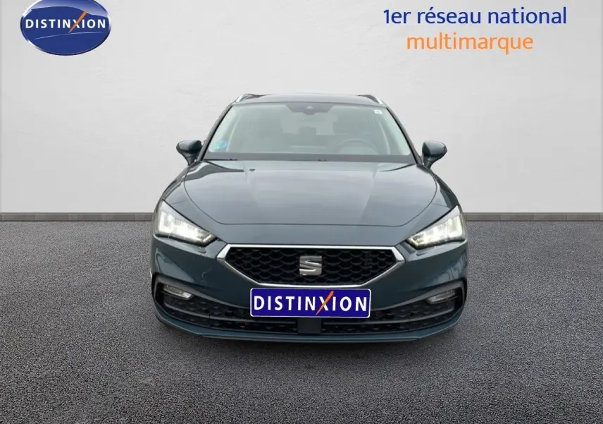 Vue frontale d'une SEAT Leon IV gris fiord, mettant en valeur sa calandre hexagonale et ses phares LED allumés.
