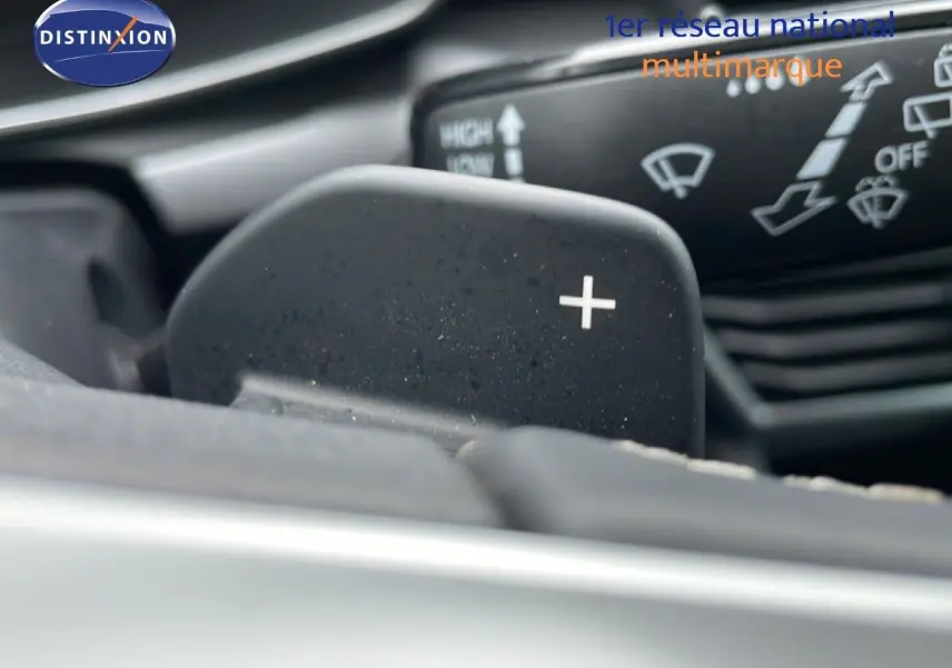 Gros plan sur la palette de changement de vitesse "+" du volant d'une SEAT LEON IV gris Fiord, version 2025.
