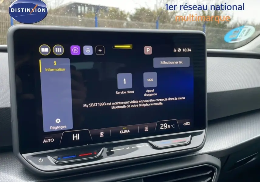Vue intérieure centrée sur l'écran tactile du tableau de bord du SEAT Leon gris Fiord, affichant les réglages climatiques.