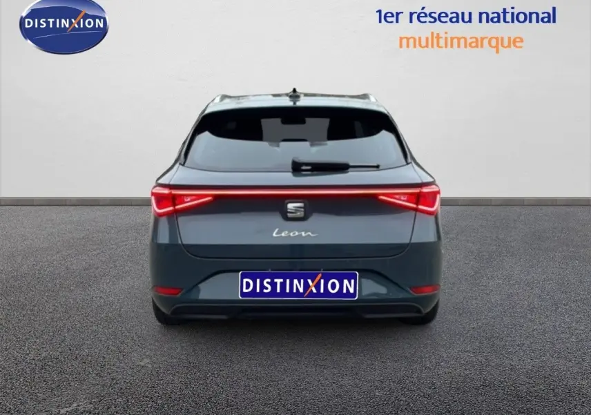 Vue arrière d'une SEAT Leon IV gris Fiord 2025 avec feux LED reliés et hayon fermé sur fond neutre.