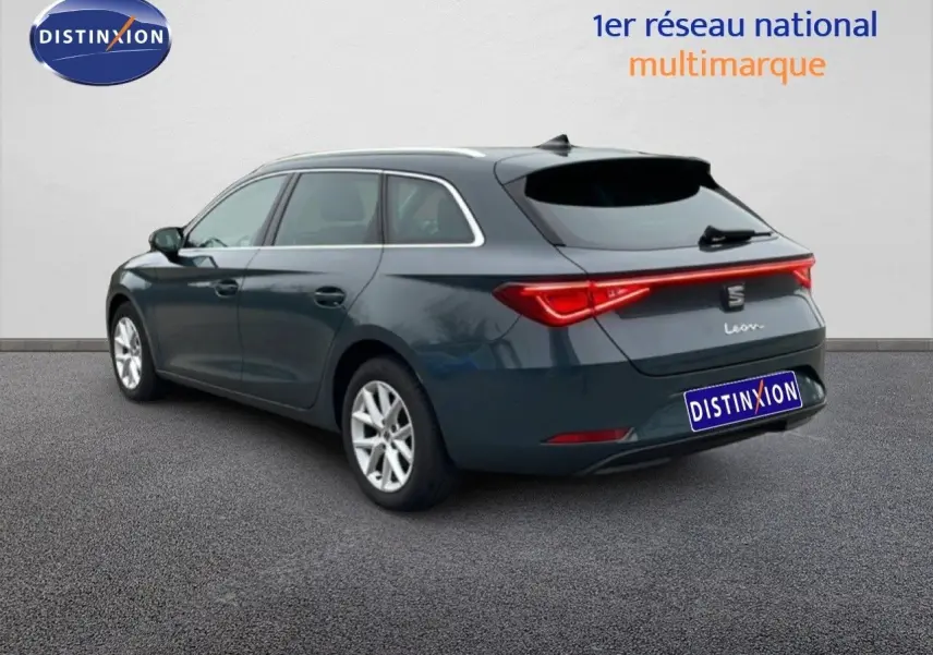 SEAT Leon IV gris Fiord vue 3/4 arrière droit, break 5 portes avec feux arrière LED allumés.