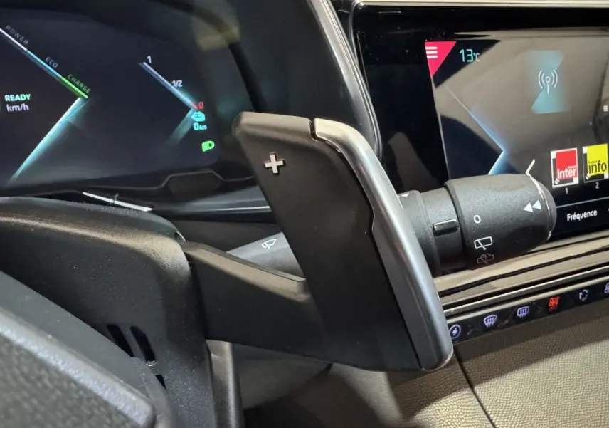 Gros plan sur la palette de changement de vitesse droite et l'écran tactile du tableau de bord du DS7 Crossback E-TENSE gris foncé.