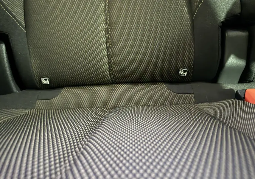 Gros plan sur la banquette arrière en tissu gris foncé du DS7 Crossback E-TENSE 225 BASTILLE + avec fixation Isofix visible.