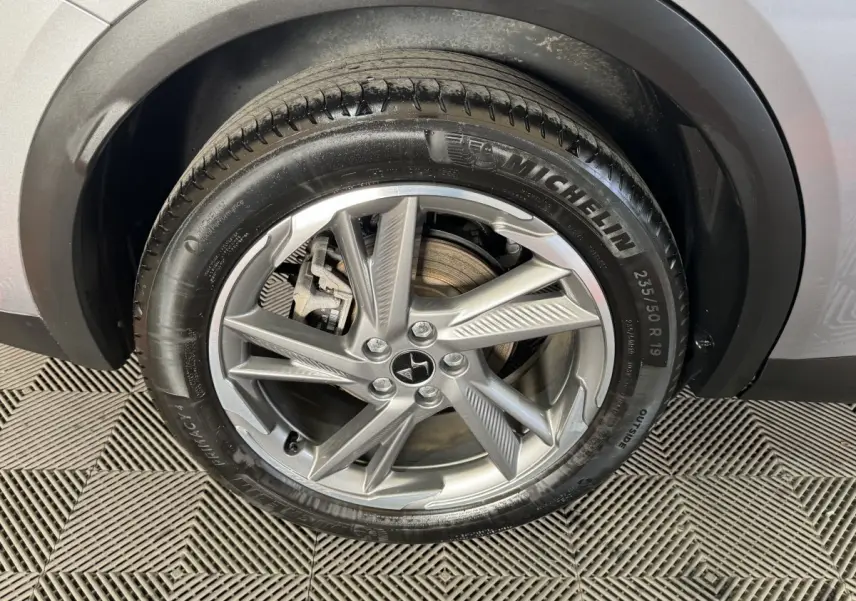 Gros plan sur la roue avant droite gris foncé du DS7 Crossback E-TENSE 225 avec jante alliage et pneu Michelin.