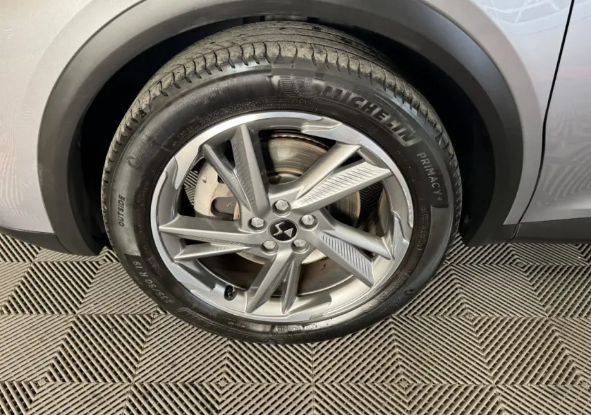 Gros plan sur la roue avant droite gris foncé du DS7 Crossback E-TENSE 225 Bastille+ avec jante alliage et pneu Michelin.