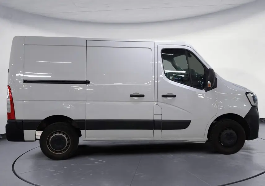 Vue latérale droite d’un Renault Master blanc L1H1 2023 avec bandeau noir et portes coulissantes sur fond neutre.
