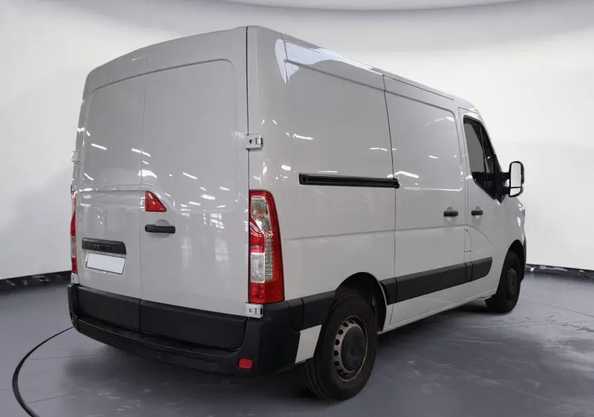 Vue 3/4 arrière droite d’un Renault Master blanc 2023 avec porte latérale coulissante et feux arrière verticaux.