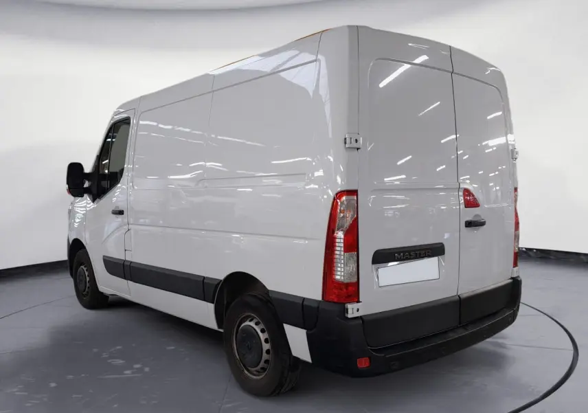 Vue 3/4 arrière droite du Renault Master blanc 2023, fourgon utilitaire avec portes arrière battantes et bande noire latérale.