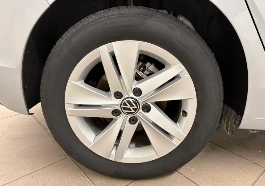 Gros plan sur la roue avant droite de la Volkswagen Golf 2.0 TDI 2025 en reflet d'argent avec jante alliage à cinq doubles branches.