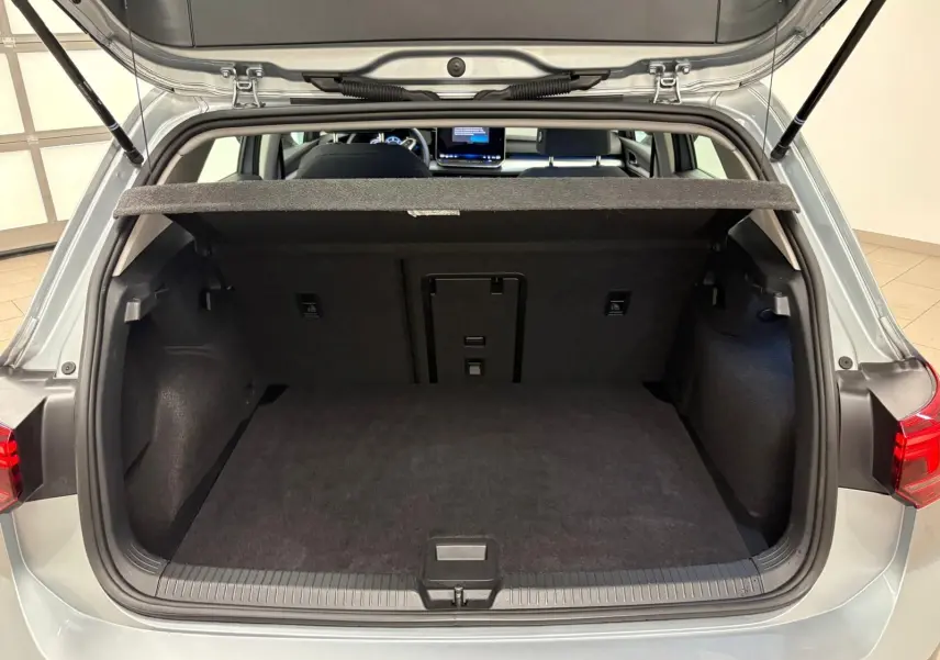 Coffre ouvert vue arrière d’une Volkswagen Golf 2.0 TDI 116 BVM6 Life Plus 2025 en reflet d’argent, intérieur noir.