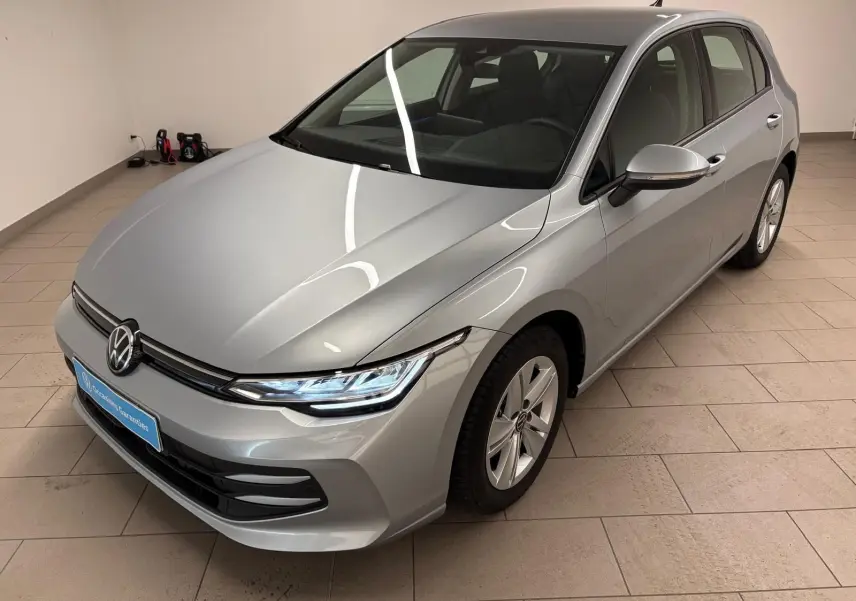 Volkswagen Golf 2.0 TDI 116 BVM6 Life Plus 2025 en reflet d'argent vue 3/4 avant droit dans un intérieur.