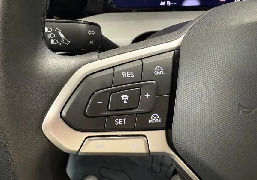 Gros plan sur les commandes au volant côté gauche de la Volkswagen Golf 2.0 TDI 2025 couleur reflet d'argent.