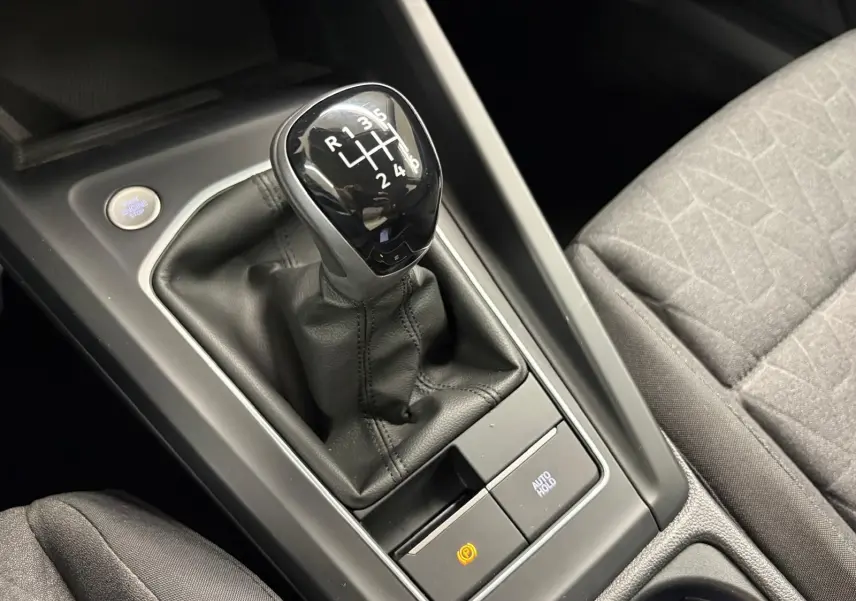 Vue rapprochée de la boîte manuelle noire et du levier de vitesses sur la console centrale d’une Volkswagen Golf 2025.