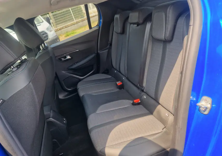 Vue intérieure côté droit des sièges arrière en tissu noir et gris d'une Peugeot 208 bleu Vertigo 2022.