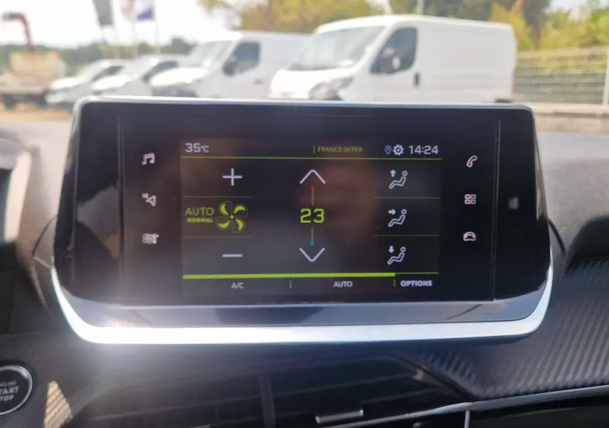 Écran tactile du système de climatisation automatique affichant 23°C dans l’habitacle d’une Peugeot 208, vue intérieure.