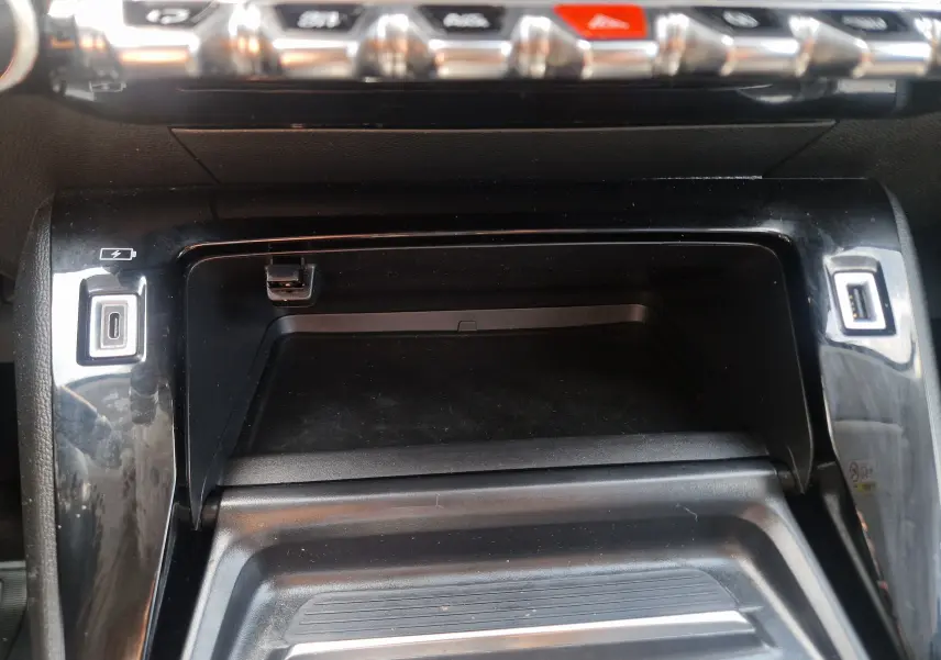 Détail de la console centrale noire du Peugeot 208 1.2 PureTech 110 Allure Pack avec ports USB visibles.