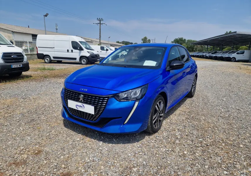 Peugeot 208 bleu Vertigo vue 3/4 avant droit sur parking avec calandre noire et feux LED distinctifs.