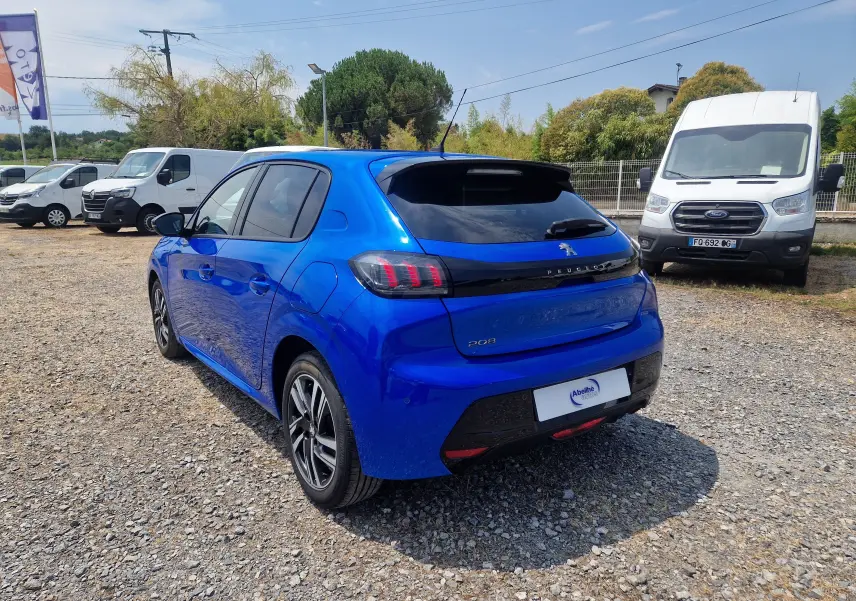 Vue 3/4 arrière droite d'une Peugeot 208 1.2 PureTech 110 Allure Pack bleu Vertigo, avec vitres teintées et jantes alliage.