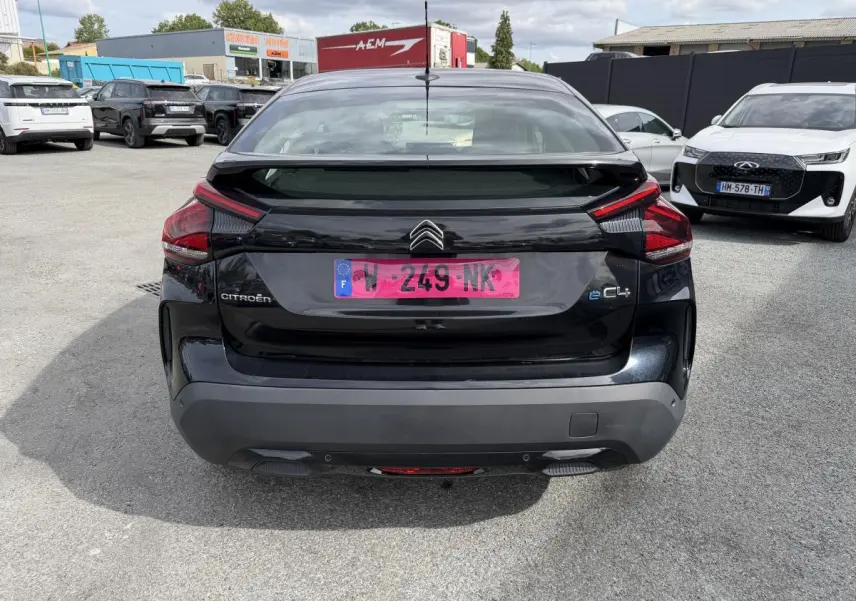 Vue arrière d'une Citroën C4 électrique noire avec inserts noir brillant et feux arrière distinctifs.