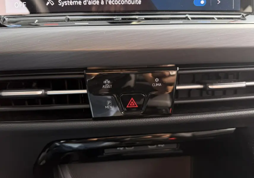 Détail du tableau de bord noir de la Volkswagen Golf VIII 2024 avec commandes d'assistance et climatisation.