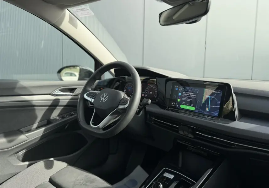 Intérieur de la Volkswagen Golf VIII 2.0 TSI 2024 vu côté conducteur, volant multifonctions cuir et écran tactile.