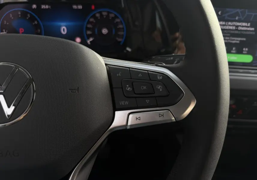 Gros plan sur le volant multifonctions cuir chauffant de la Volkswagen Golf VIII 2.0 TSI 190 DSG Style, avec tableau de bord numérique en arrière-plan.