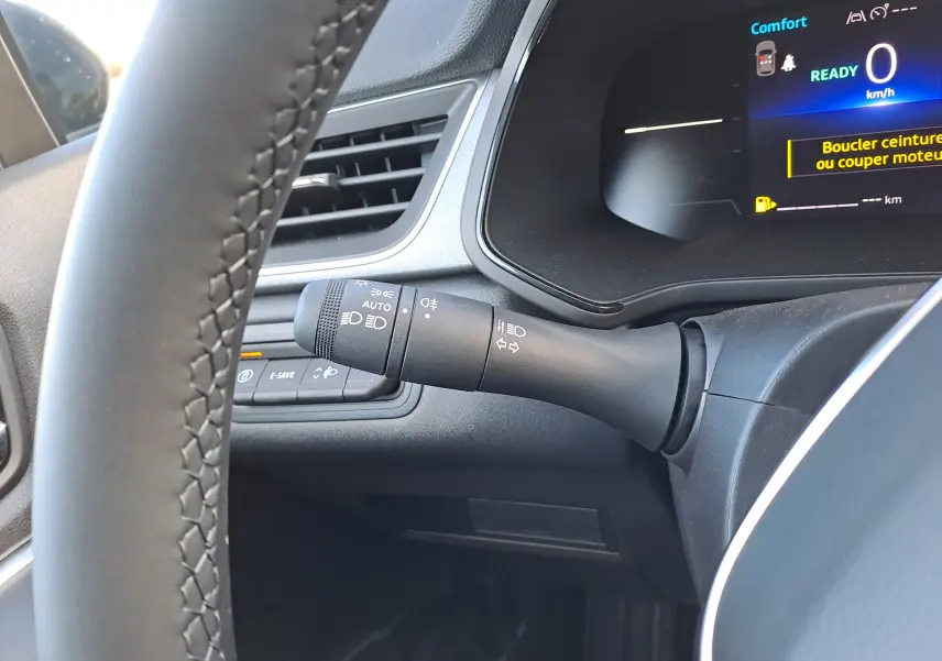 Gros plan sur la commande des phares et clignotants à gauche du volant du Renault Captur blanc nacré 2025.