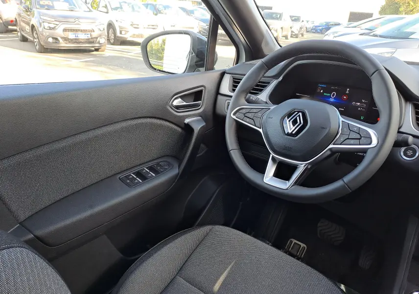 Vue intérieure côté conducteur du Renault Captur 2025, volant multifonction et tableau de bord numérique visibles.