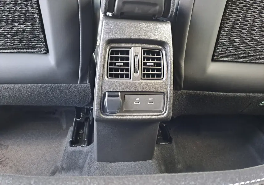 Vue rapprochée des aérateurs arrière et ports USB-C noirs entre les sièges arrière du Renault Captur blanc nacré 2025.