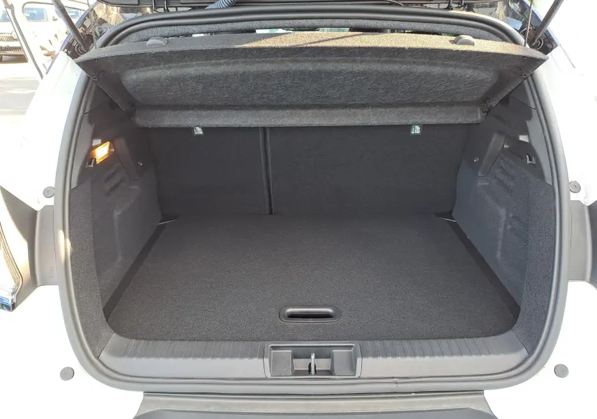 Coffre ouvert vu de l'arrière d'un Renault Captur blanc nacré avec toit gris Highland, espace de rangement vide et propre.