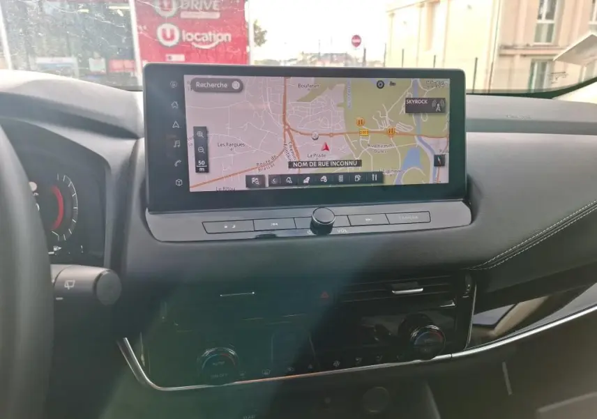Vue intérieure du tableau de bord du Nissan Qashqai e-POWER 2023 avec écran tactile de navigation et commandes intégrées.