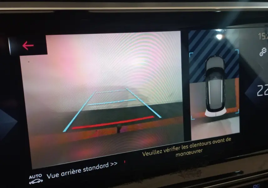 Écran tactile affichant la caméra de recul et vue aérienne du DS7 Crossback gris foncé en marche arrière.