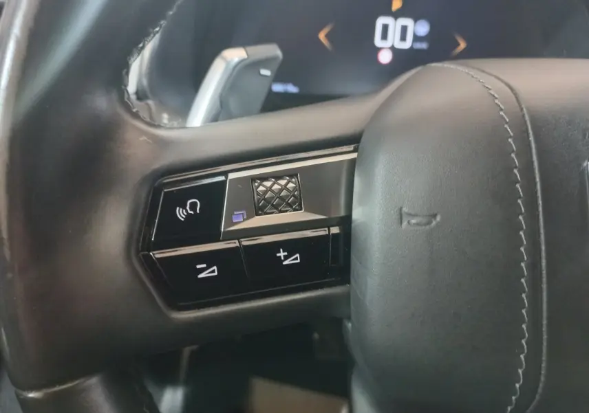 Gros plan sur les commandes gauche du volant cuir noir du DS7 Crossback 2021, avec touches de volume et reconnaissance vocale.