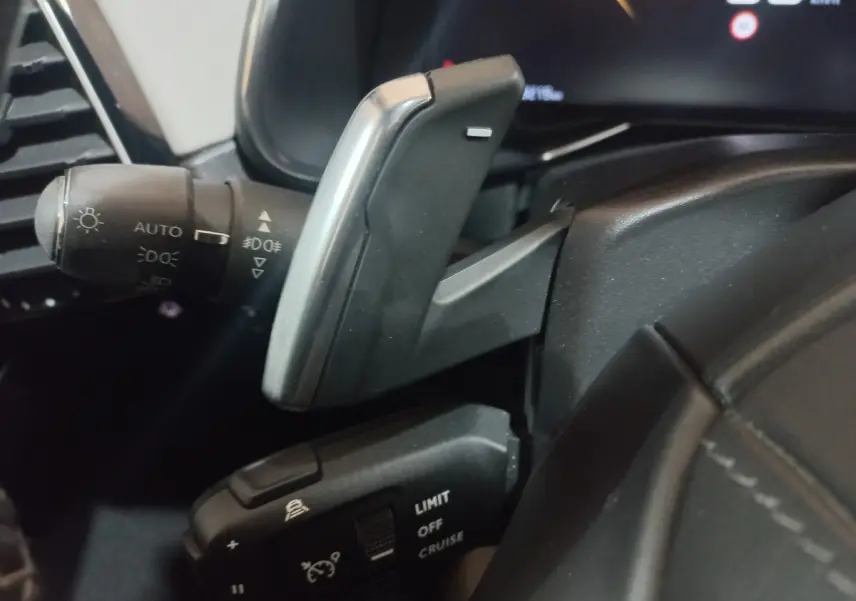 Gros plan sur les commandes au volant et levier de régulateur de vitesse dans l’habitacle noir du DS7 Crossback 2021.