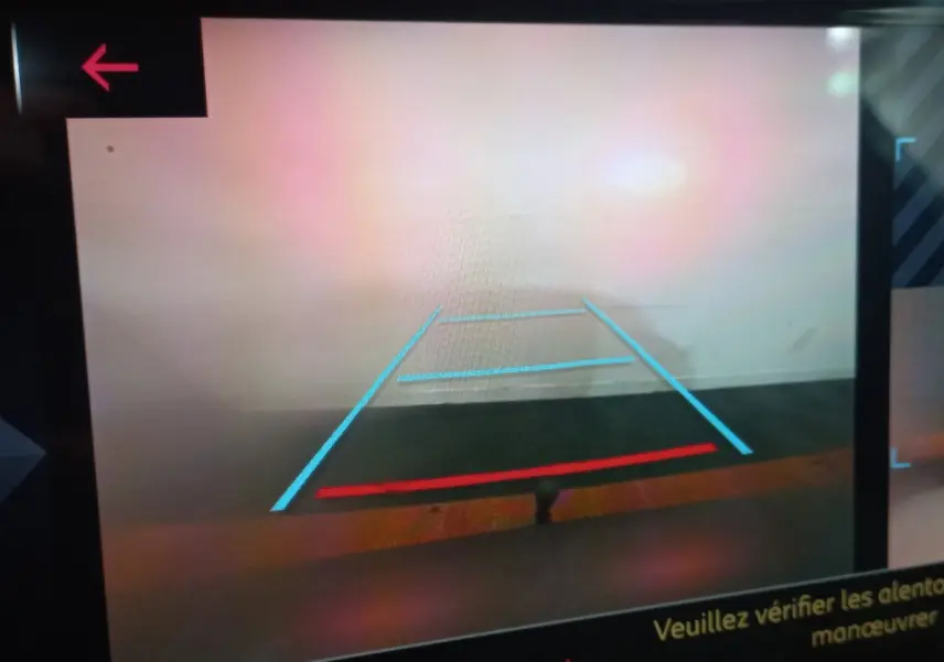 Vue caméra de recul du DS7 Crossback gris foncé, affichant les lignes de guidage bleues et rouges sur écran tactile.