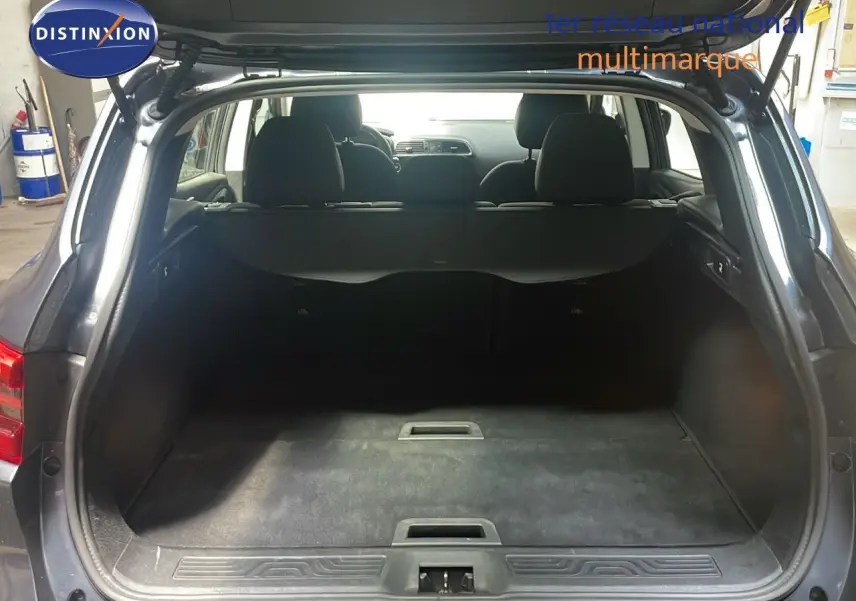 Coffre ouvert vu de l'arrière d'un Renault Kadjar gris titanium métal, montrant l'espace de chargement et les sièges arrière.