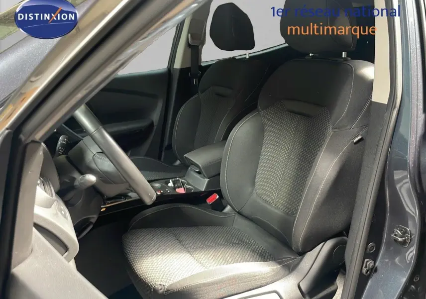 Vue intérieure côté conducteur du Renault Kadjar gris titanium, mettant en valeur les sièges en tissu noir et la console centrale.