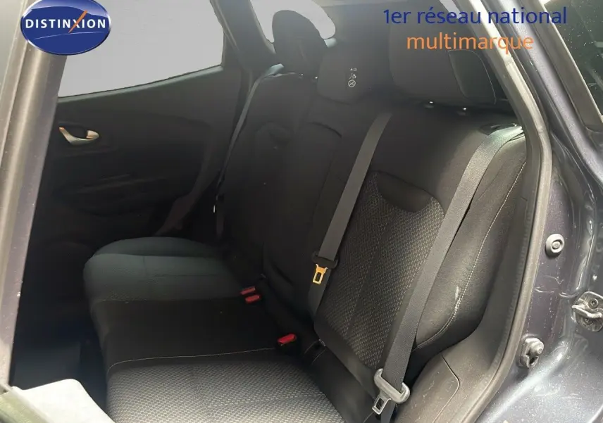 Vue intérieure arrière droite du Renault Kadjar gris titanium, montrant la banquette arrière en tissu noir avec ceinture de sécurité.