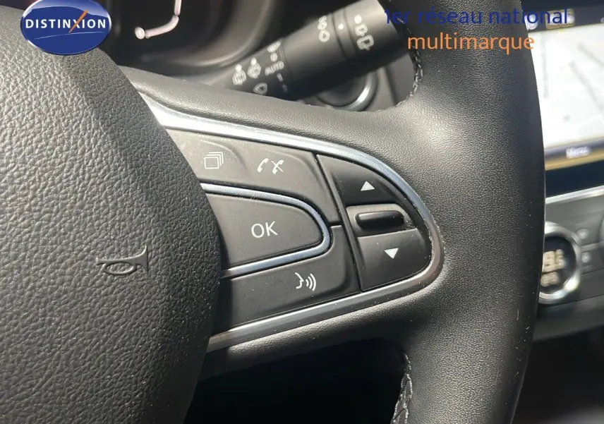 Gros plan sur les commandes au volant du Renault Kadjar gris titanium, avec affichage partiel de l’écran tactile et tableau de bord.