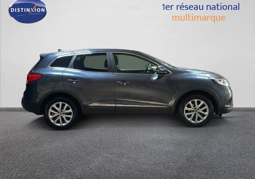 Profil droit d'un Renault Kadjar gris titanium metal 2021, SUV compact avec jantes alliage 17 pouces et vitres teintées.