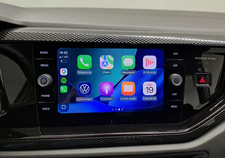 Écran tactile central de la Volkswagen Polo 2024 affichant Apple CarPlay avec commandes physiques autour.