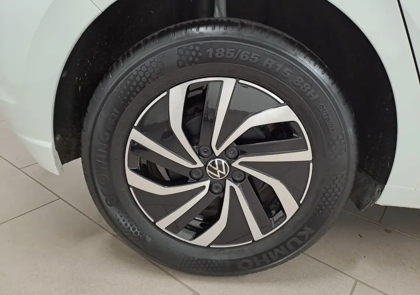 Gros plan sur la roue avant droite d'une Volkswagen Polo blanc pur 2024 avec jante alliage noire et argentée.