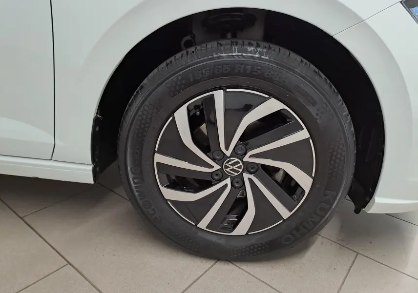 Gros plan sur la roue avant droite d'une Volkswagen Polo blanche 2024, avec jante alliage au design moderne bicolore.