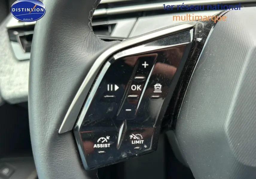Gros plan sur les commandes multifonctions à gauche du volant cuir du Peugeot 3008 gris titane 2025.