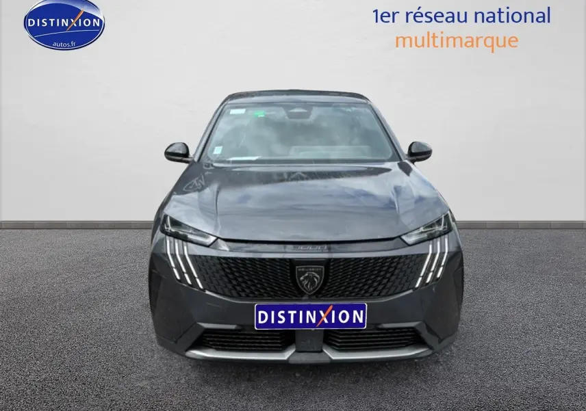 Vue avant centrée du Peugeot 3008 gris titane 2025 avec calandre noire et feux LED distinctifs en griffes.