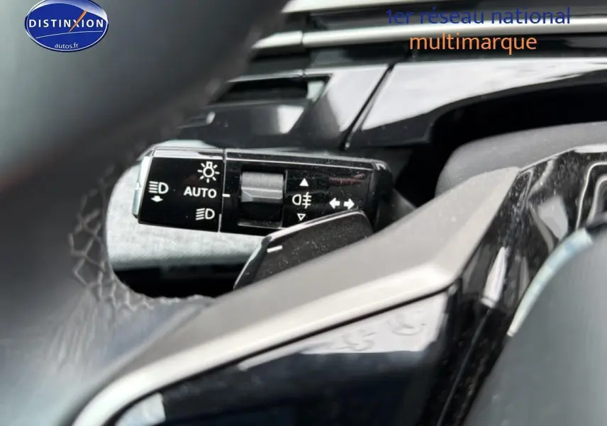Gros plan sur la commande des phares et clignotants du Peugeot 3008 gris titane, vue depuis le volant cuir.