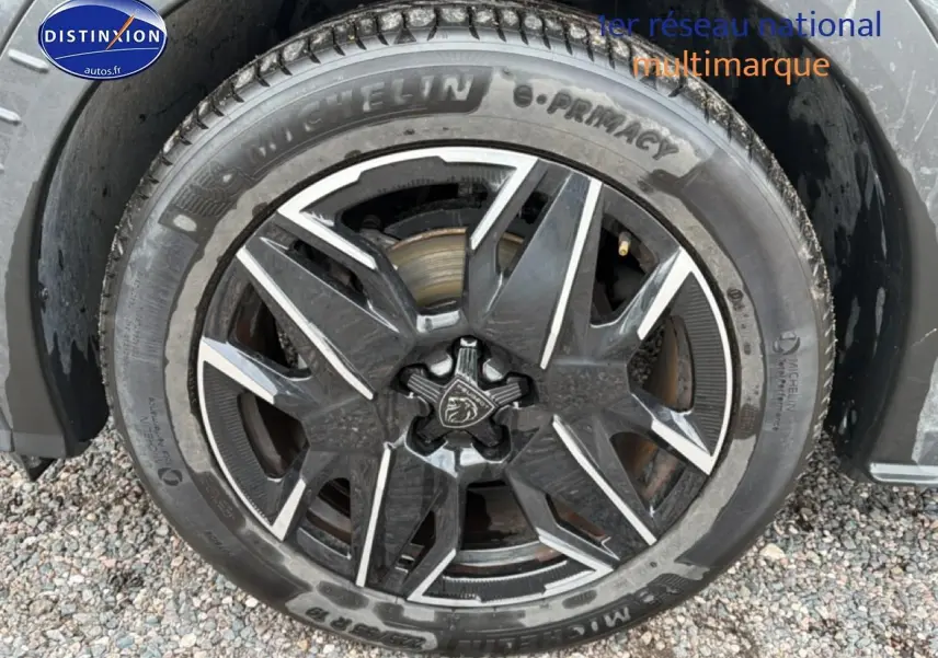 Gros plan sur la jante alu noire et argentée du côté avant droit d’un Peugeot 3008 gris titane.