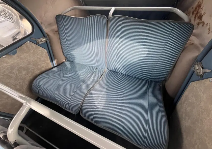 Vue intérieure arrière du Citroën 2CV 1960 montrant la banquette à rayures bleues et blanches dans un habitacle bleu clair.