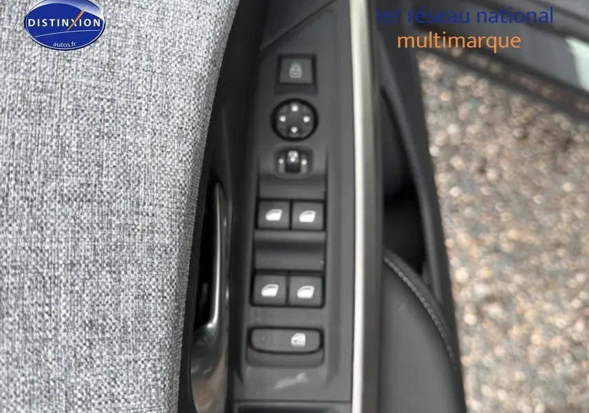Gros plan sur la commande des vitres électriques côté conducteur d’un Peugeot 3008 gris titane, porte ouverte.