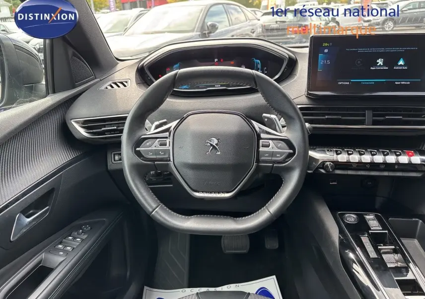 Vue intérieure centrée sur le volant cuir noir du Peugeot 3008 Hybrid 2024, avec tableau de bord digital et écran tactile.